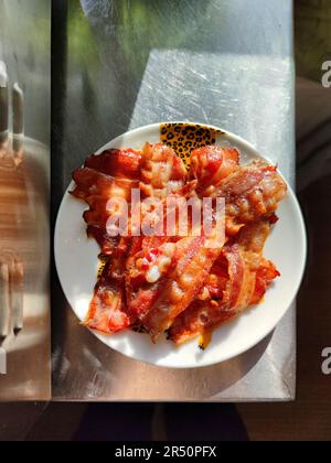 Fette di pancetta fritte sul piatto Foto Stock