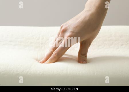 Donna toccante ortopedico cuscino in schiuma memoria, primo piano Foto Stock