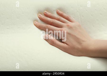 Donna toccante ortopedico cuscino in schiuma memoria, primo piano Foto Stock