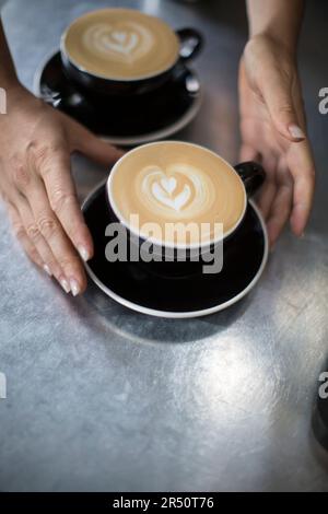 Cappuccino con disegno ad albero in schiuma; tazza bianca e piattino Foto Stock