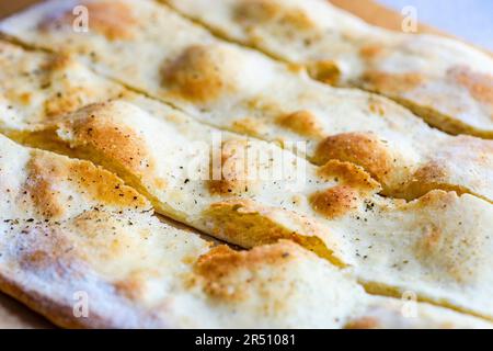 Focaccia italiana appena sfornata tagliata a strisce (primo piano) Foto Stock