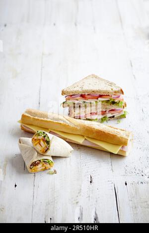 Selezione di involtini, baguette e sandwhiches ripieni di pollo e insalata, prosciutto e formaggio, pomodori, cipolla e formaggio Foto Stock