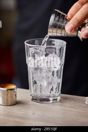 Preparare l'espresso martini, versare la vodka in un bicchiere Foto Stock