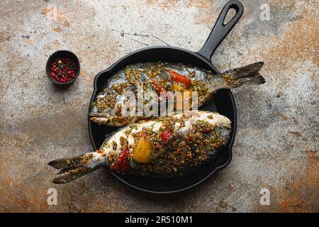 Due pesci crudi dorado farciti con verdure e condimenti pronti per essere cucinati Foto Stock