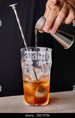 Preparare un cocktail vecchio stile, aggiungendo whisky Foto Stock