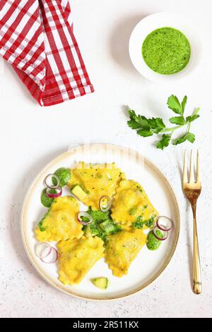 Ravioli allo zafferano con ricotta, rucola e pesto Foto Stock