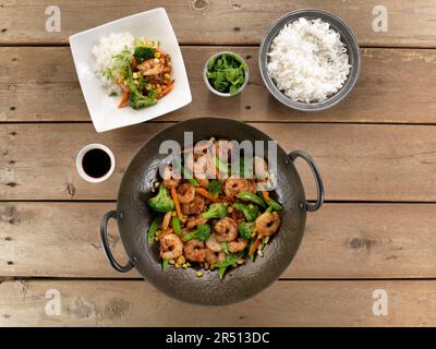 Gamberi fritti con verdure in un wok servito con riso Foto Stock