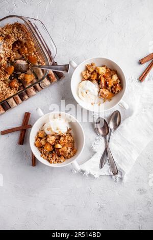 Crumble di mele e persimmon con gelato alla vaniglia Foto Stock