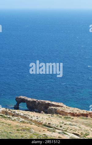 Un ponte naturale, un arco di roccia Ras il-Hamrija, Ghar Hanex, si trova sotto i templi di Mnajdra a Qrendi, Malta. Turismo, vacanze, viaggi e ge Foto Stock