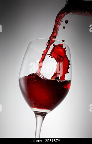 Vino rosso che viene versato Foto Stock