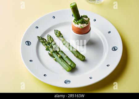 Punte di asparagi con un uovo bollito morbido e erba cipollina Foto Stock