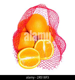 Vista ravvicinata di un sacchetto a rete rossa con arance fresche e di succo intere e tagliate isolate su sfondo bianco. Foto Stock