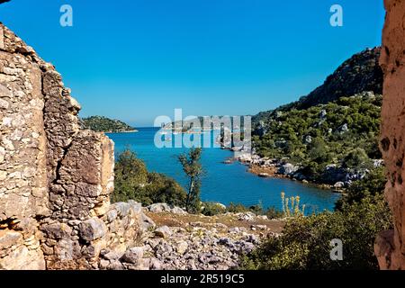 Barche visto attraverso le rovine del castello sulla via Licia, Üçağız, Turchia Foto Stock