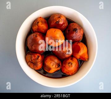 Cotogne arrostite al forno in sciroppo di vino rosso speziato alla cannella secondo una ricetta di Maggie Beer Foto Stock