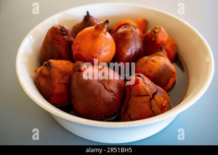 Cotogne arrostite al forno in sciroppo di vino rosso speziato alla cannella secondo una ricetta di Maggie Beer Foto Stock