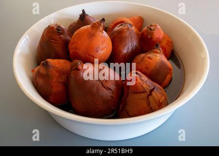 Cotogne arrostite al forno in sciroppo di vino rosso speziato alla cannella secondo una ricetta di Maggie Beer Foto Stock