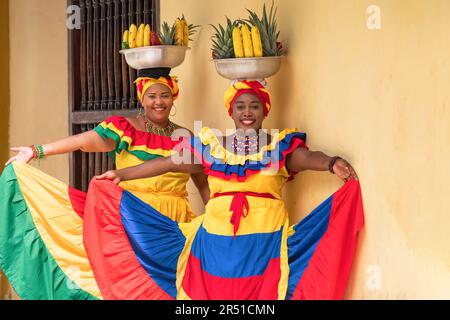 Felice, sorridente Palenquera venditori di frutta fresca di strada nel centro storico di Cartagena, Colombia. Allegre donne afro-colombiane in abiti tradizionali. Foto Stock