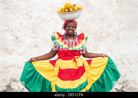 Allegro fornitore di frutta fresca strada aka Palenquera nella città vecchia di Cartagena de Indias, Colombia. Donna afro-colombiana in abbigliamento tradizionale. Foto Stock
