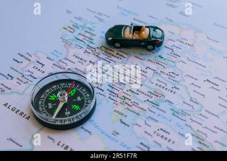 Viaggio in Europa o paesi europei concept photo. Bussola e una macchina giocattolo sulla mappa Europa. Foto Stock