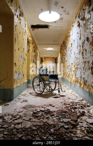 Una sedia a rotelle scricchiolante abbandonata. GALWAY, IRLANDA: QUESTE immagini SPAVENTOSE mostrano un famigerato ospedale psichiatrico abbandonato in Irlanda lasciato a marciume dopo husi Foto Stock