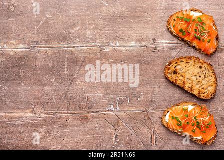 Fotografia di cibo bianco di pane tostato con salmone affumicato, formaggio cremoso, insalata di crescione, colazione, sandwich, bruschetta, filetto, fetta, pesce Foto Stock