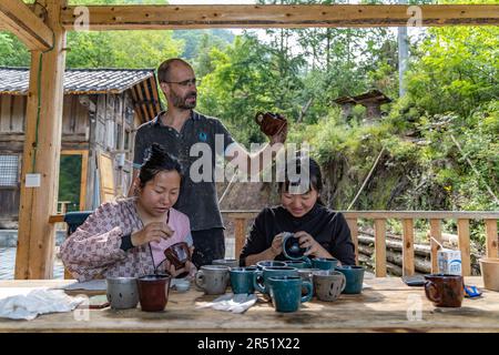 (230531) -- CHONGQING, 31 maggio 2023 (Xinhua) -- Vincent Cazeneuve esamina un pezzo di lacca lucidata al di fuori del suo studio nel villaggio di Songbai di Beiping Town, Chengkou County, sud-ovest della Cina Chongqing Municipality, 29 maggio 2023. Lo studio di Vincent Cazeneuve, una casa di legno a due piani circondata da alberi laccati, si trova nel profondo delle montagne Daba nella città di Beiping, nella contea di Chengkou, nel sud-ovest del comune di Chongqing. Affascinato dall'arte della lacca, l'artista francese è venuto in Cina 15 anni fa con l'obiettivo di trovare le specie adatte di lacca per realizzare opere d'arte della lacca. Lui Foto Stock