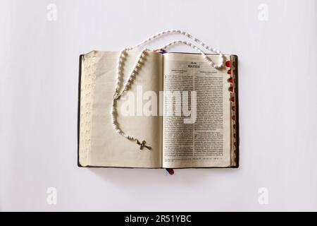 Bibbia e Rosario (Beati di preghiera) in cima l'uno all'altro. La Bibbia è una delle opere più tradotte Foto Stock