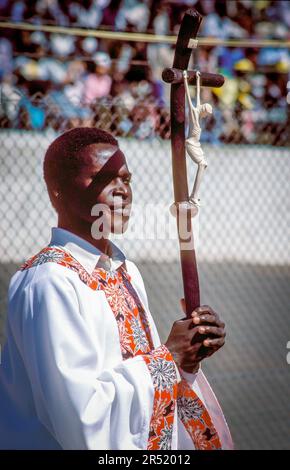 Mozambico, Maputo; sacerdote cattolico romano che tiene un crocifisso nello stadio di calcio di Maputo in occasione della visita di Papa Giovanni Paolo II nel 1988. Foto Stock