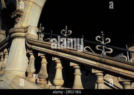 Primo piano di lavori in metallo in stile art nouveau su una balaustra di pietra all'ingresso della scala della biblioteca di Armley, Leeds. Foto Stock