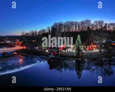 Clinton Red Mill - veduta aerea dello storico Red Clinton Mill lungo il Main Street Bridge illuminato. Il fiume Raritan riflette l'iconico mi Foto Stock