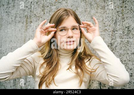 Ritratto all'aperto di giovane ragazza felice adolescente che indossa gli occhiali Foto Stock