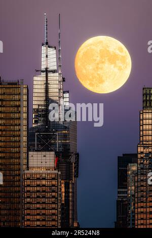 Moon by the Summit NYC - Vista ravvicinata dell'intera Luna di Harvest che si erge da un Vanderbilt's Summit nel centro di Manhattan presso l'iconico skylin di New York City Foto Stock