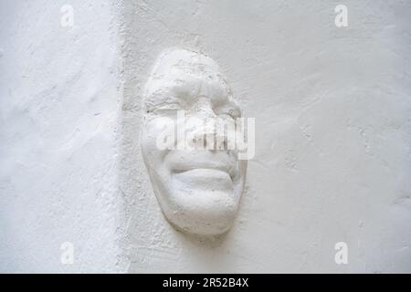 Scultura di un viso mans sulla costruzione di oin Hoxton zona di Londra. Foto Stock