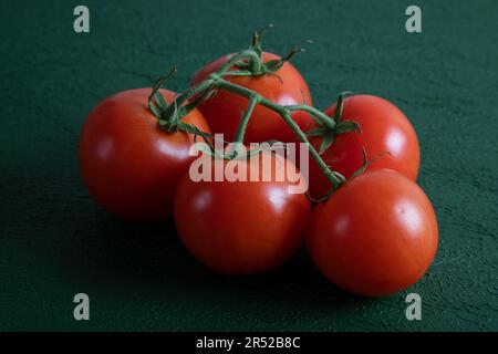 Un gruppo di pomodori d'uva su uno sfondo verde, vista dall'alto Foto Stock