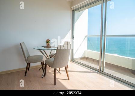 ventanales de habitacion en casa de campo iluminados, con acabados de parquet brillante y paredes color blanco Foto Stock