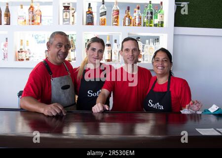 I camerieri cubani sorridono alla macchina fotografica di fronte alle bevande alcoliche a la Habana Cuba. Foto Stock