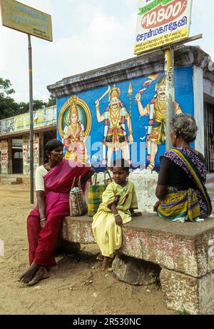 Abitanti del villaggio in attesa di un autobus, seduti su una panchina di pietra a Pathamadai Pattamadai vicino Tirunelveli Thirunelveli, Tamil Nadu, India del Sud, India, Asia Foto Stock