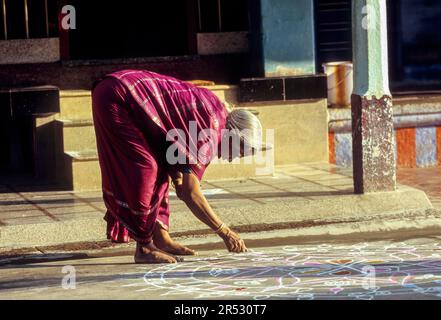 Una donna Brahmin che disegna un kolam davanti alla sua casa Agraharam indossando un madisar sari saree a Sundarapandiapuram Sundarapandyapuram vicino Courtalam Foto Stock