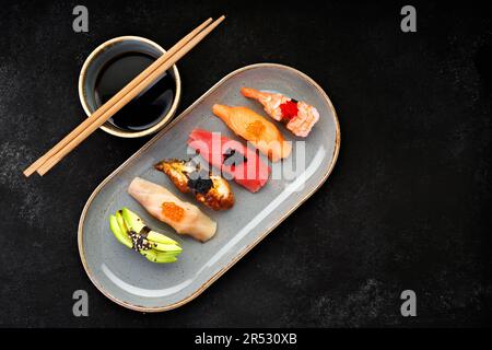 squisito sushi nigiri caratterizzato da una varietà di sapori tra cui gamberi, anguilla, avocado, salmone e tonno Foto Stock