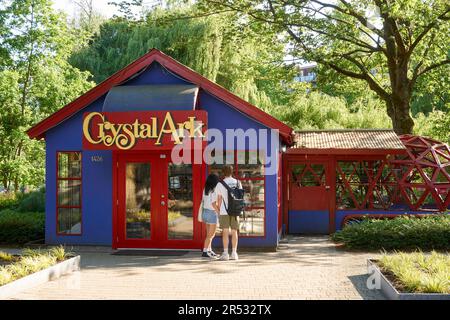 Giovane coppia di uomini e donne in piedi di fronte al negozio Crystal Ark su Granville Island, Vancouver, BC, Canada Foto Stock