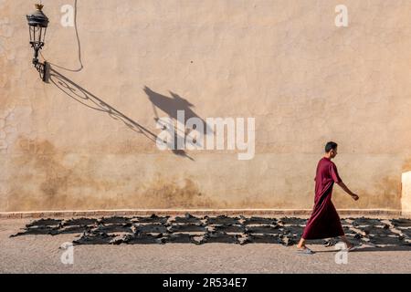 Un uomo cammina davanti alla moschea di ben Youssef, Marrakech, Marocco Foto Stock