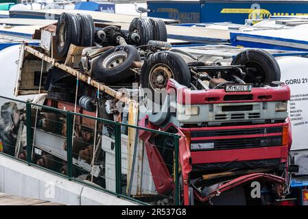 Barcellona, Spagna - 17 aprile 2023: Container con motori e un camion rotto capovolto accatastato come rottame di metallo per il riciclaggio al carico d Foto Stock