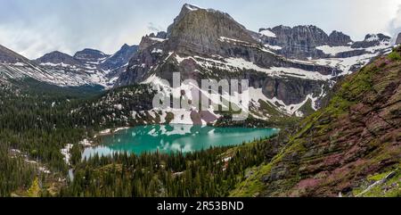 Lago Grinnell - la luce del sole primaverile della sera splende sul colorato lago Grinnell e sull'aspro monte Gould and Angel Wing, Many Glacier, Glacier National Park, MT. Foto Stock