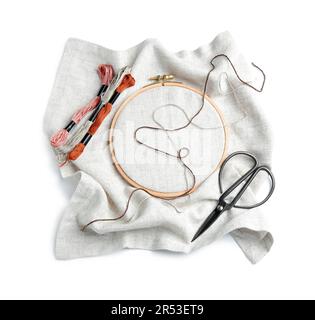 Cerchio in legno ricamato con tela, fili di moulin e forbici isolato su sfondo bianco Foto Stock
