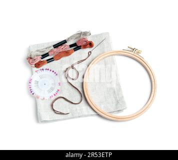 Cerchio in legno ricamato con tela, fili moulin e spille a sfera isolate su sfondo bianco Foto Stock