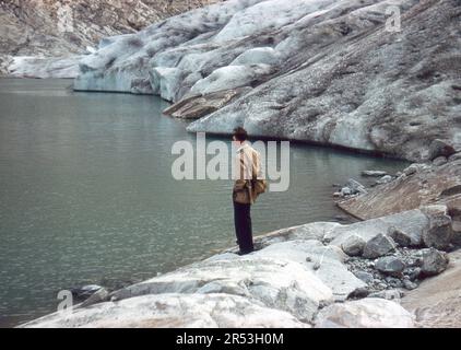 Nigardsbreen, Norvegia. Circa. 1960 – un uomo che si trova ai piedi del Nigardsbreen, un braccio di ghiacciaio del grande ghiacciaio Jostedalsbreen situato nella valle di Jostedalen nel comune di Luster, nella contea di Vestland. Foto Stock