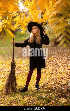 Immagini Stock - Giovane Donna In Abito Scuro E Cappello Da Strega Tiene In  Mano Una Lanterna Con Candele E Illumina La Foresta. Costume Da Festa Di  Halloween. Parco Con Alberi Autunnali..