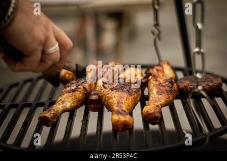 Mano tagliata di pollo grigliato su un barbecue Foto Stock