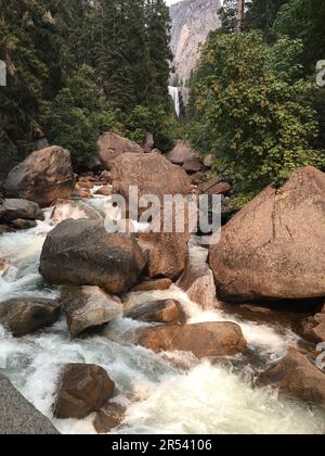 L'acqua del fiume Merced e le cascate di Vernal sgorgano intorno a massi, rocce e pietre nel Parco Nazionale di Yosemite Foto Stock