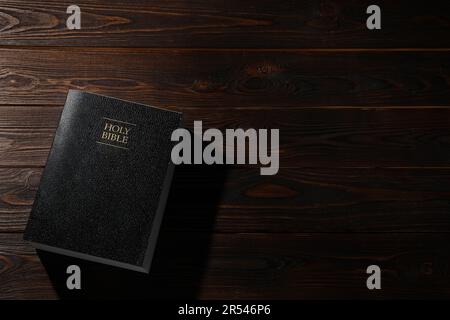 Bibbia su tavolo di legno, vista dall'alto con spazio per il testo. Libro religioso cristiano Foto Stock